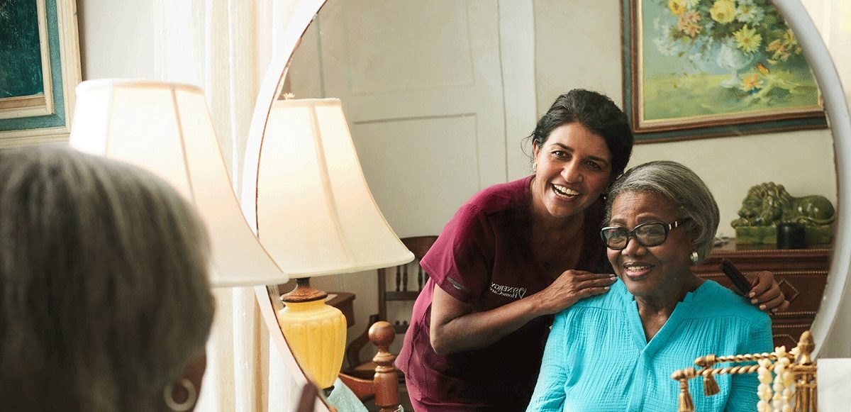 A SYNERGY HomeCare care professional laughing with her client at home.